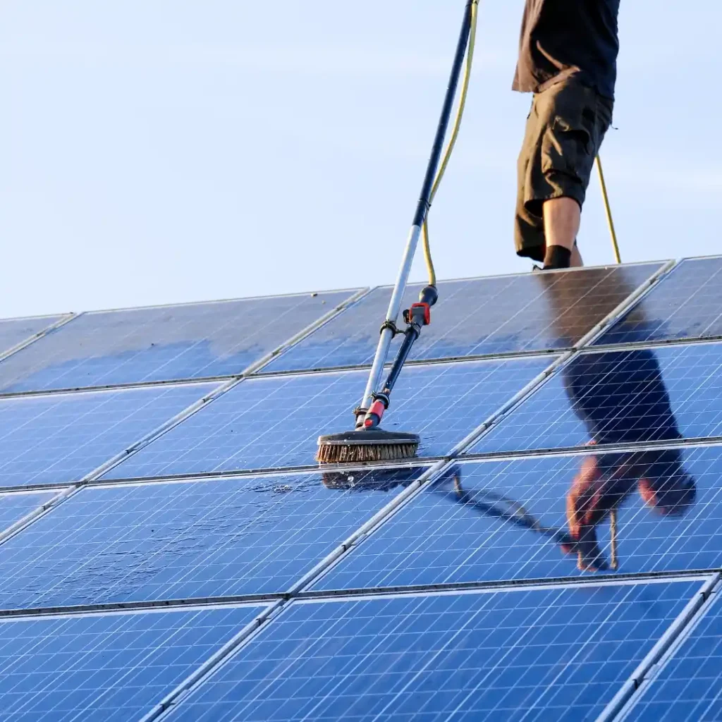 A technician using specialized tools to clean rooftop solar panels, ensuring maximum energy efficiency and optimal performance.