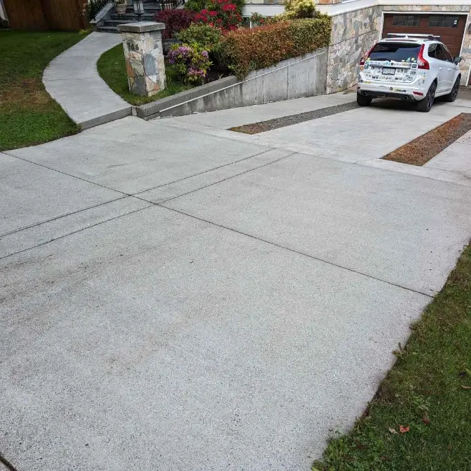 A freshly pressure-washed outdoor space in Saanich, BC, with clean siding, driveway, and patio.