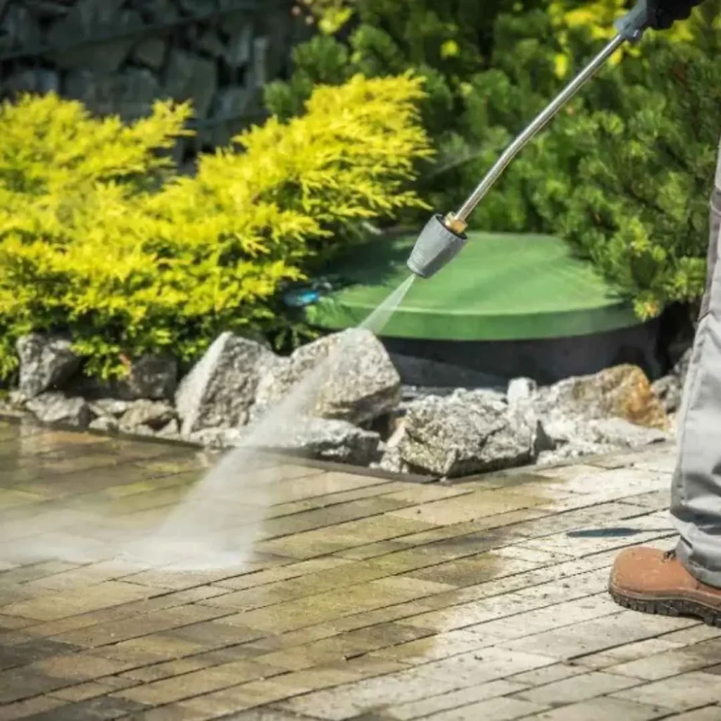 A pressure washing specialist cleaning an outdoor patio with a high-pressure washer in Colwood, BC.