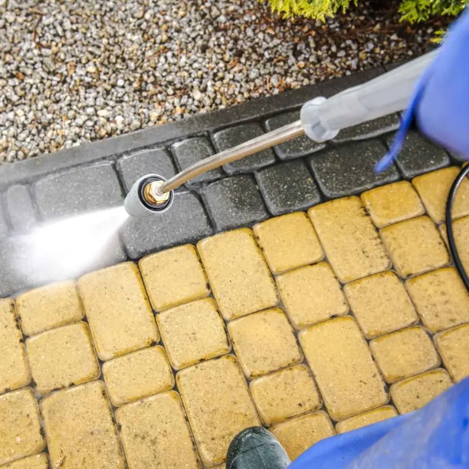 Professional pressure washing service in Brentwood Bay cleaning a stained residential driveway.